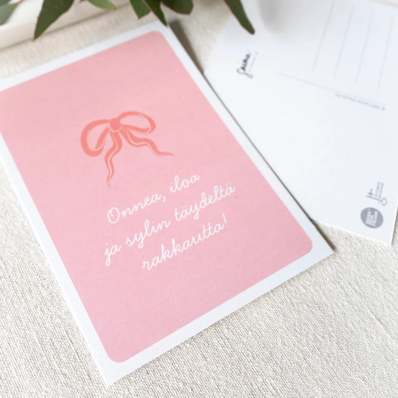 Saima Visualsin Rusetti-kortti tekstilä "onnea, iloa ja sylin täydeltä rakkautta!"