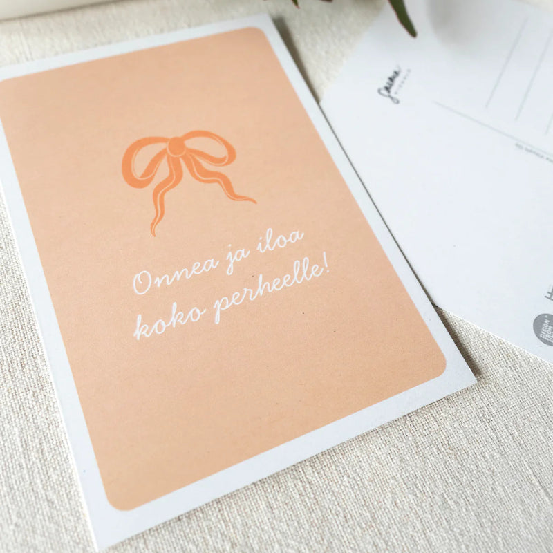 Saima Visualssin Rusetti -kortti tekstillä "onnea ja iloa koko perheelle".