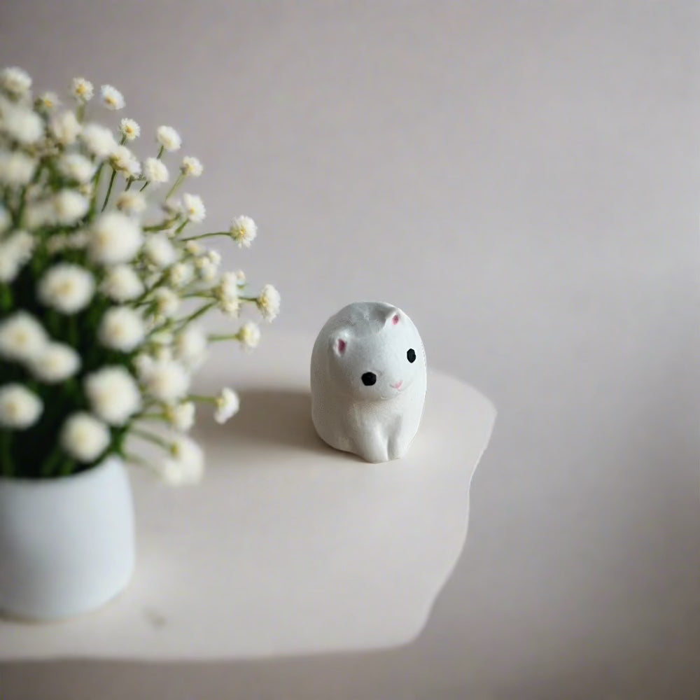 SÖPÖn pieni keraaminen valkoinen kissa pienillä yksityiskohdilla.