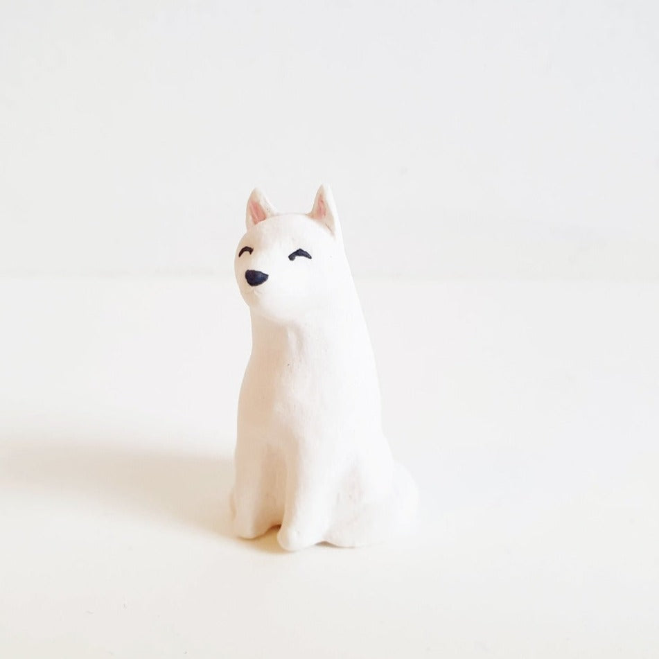 SÖPÖn pieni keraaminen valkoinen kettu -figuuri pienillä maalatuilla yksityiskohdilla. Kaarnavillassa.