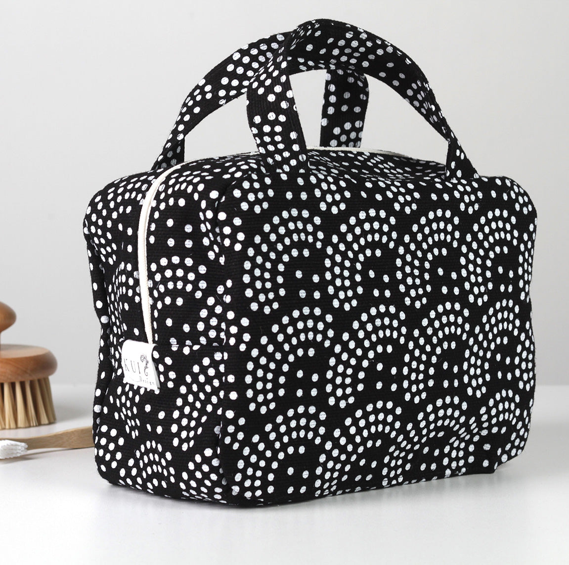 Kui designin Helmi-toilettilaukku. Musta pohjaväri, jossa valkoinen kuosi.