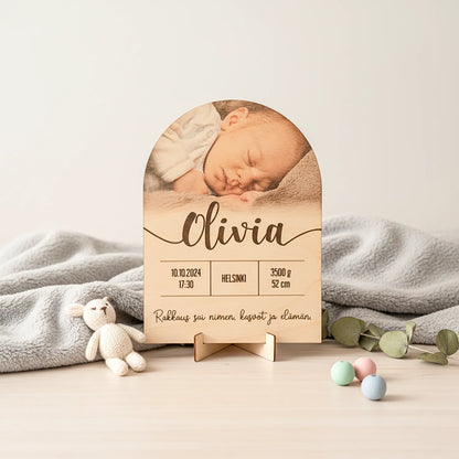 Syntymätaulu, jossa lapsen nimi, kuva, syntymäaika, paino, pituus, ja kustomoitava teksti.