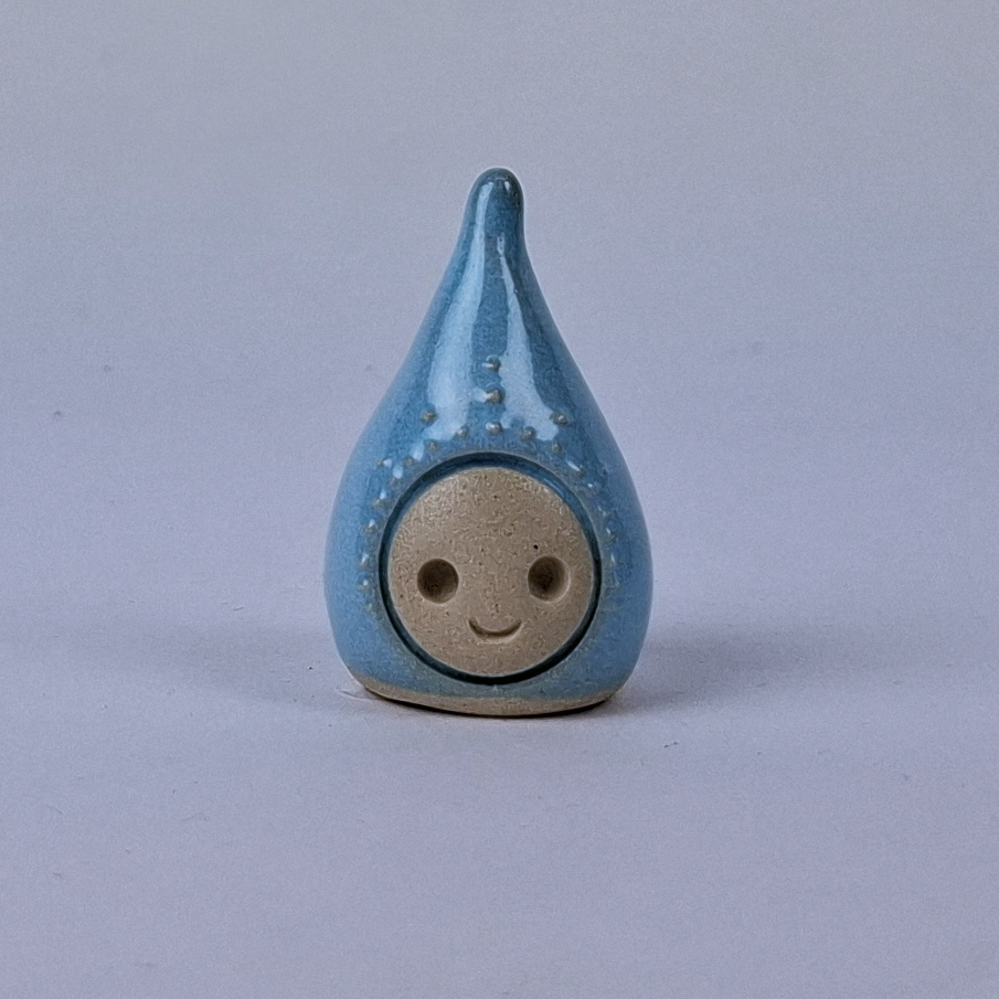 Vaaleansininen  keraaminen figuuri jonka pää kapenee ylöspäin