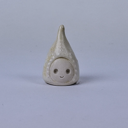 Valkoinen  keraaminen figuuri jonka pää kapenee ylöspäin