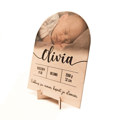Syntymätaulu, jossa lapsen nimi, kuva, syntymäaika, paino, pituus, ja kustomoitava teksti.