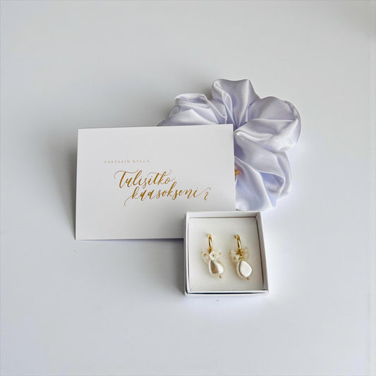 Tulisitko kaasokseni -kortti, valkoinen hiusdonitsi ja valkoiset korvakorut.