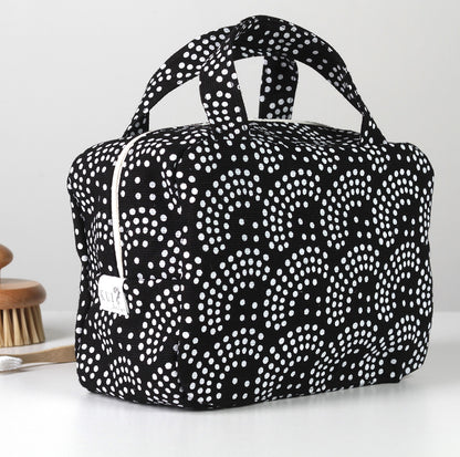 Kui designin Helmi-toilettilaukku. Musta pohjaväri, jossa valkoinen kuosi.