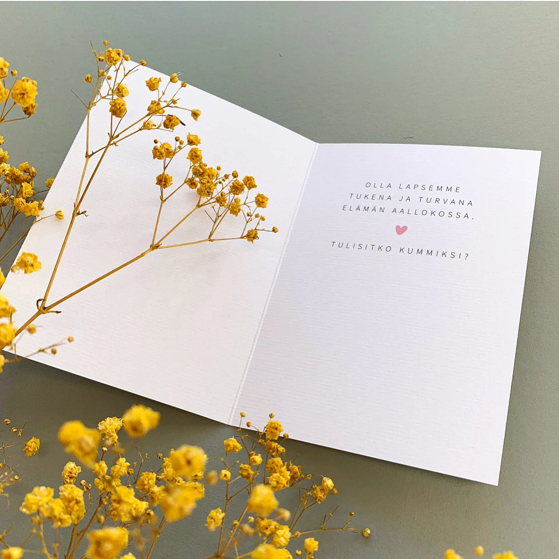 Kortissa teksti "olla lapsemme tukena ja turvana elämän aallokossa, tulisitko kummiksi?"