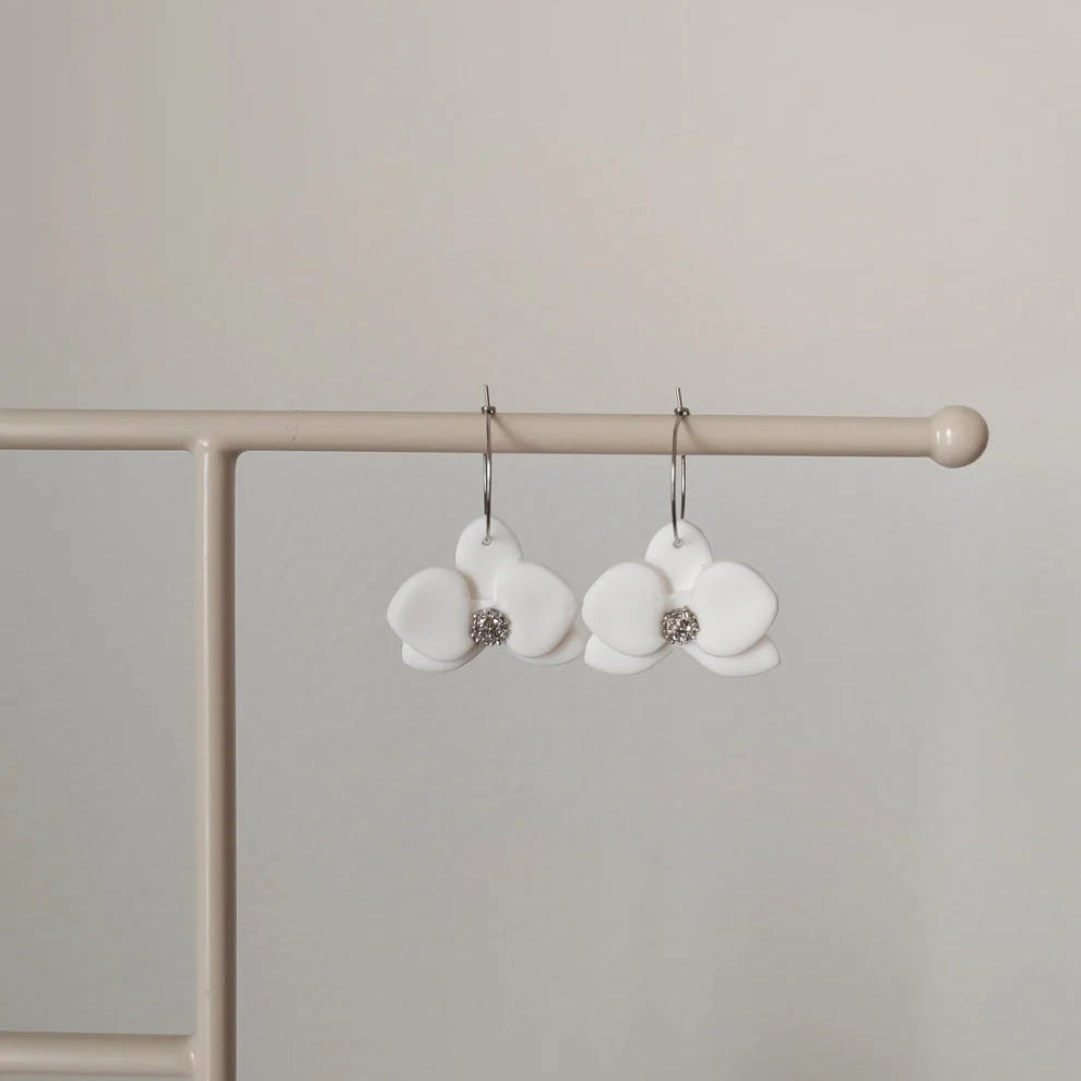 Valkoiset roikkuvat orkidea korvakorut.