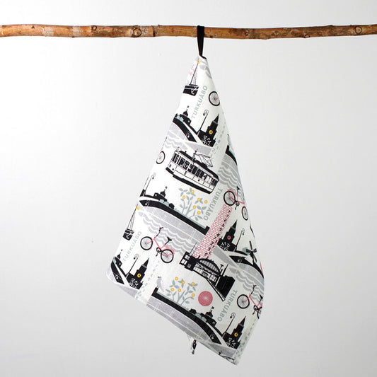 Kui designin Tälpual ja toispual-pellavapyyhe. Pohjaväri valkoinen, Roosan värisiä Turku-aiheisia kuvia.